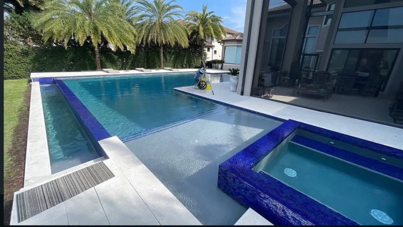 Rectangular swimming pool with tanning ledge, spa, and palm trees in Central Florida